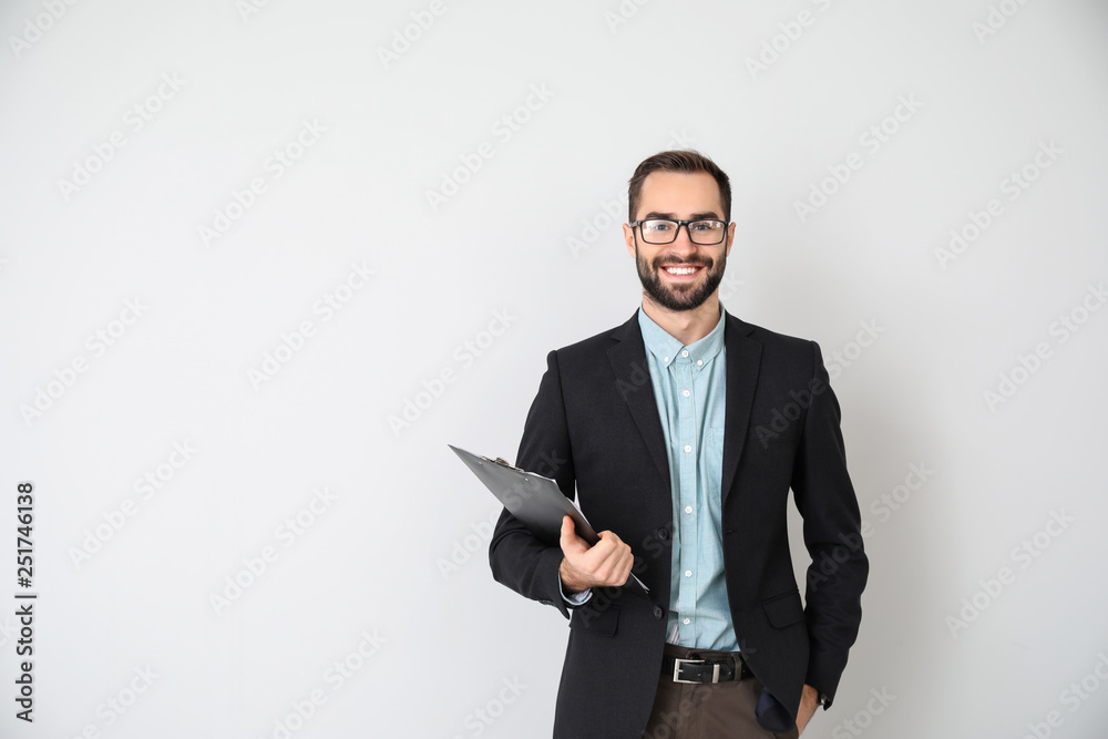 Portrait of young businessman on light background - obrazy, fototapety, plakaty 
