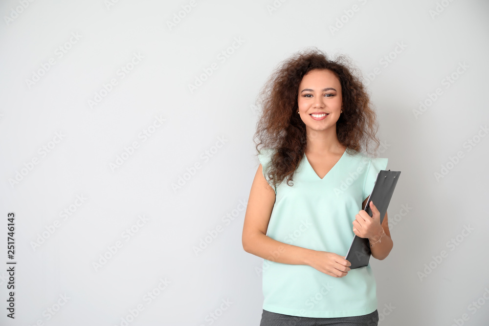 Portrait of young businesswoman on light background - obrazy, fototapety, plakaty 