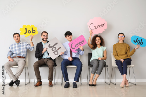 Young people holding speech bubbles with words JOB and CAREER indoors