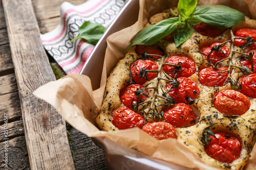 Baking dish with tasty Italian focaccia on wooden table photo