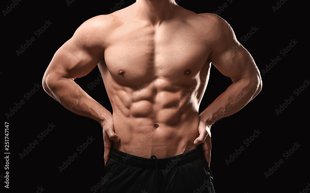 Muscular bodybuilder on dark background