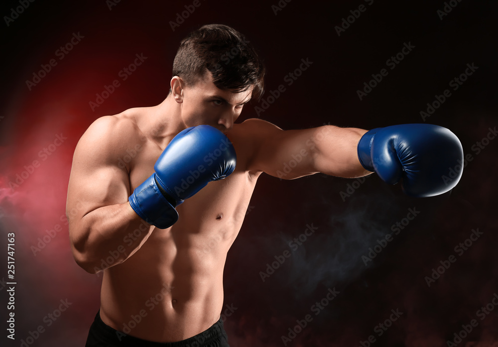 Attractive young boxer on dark background