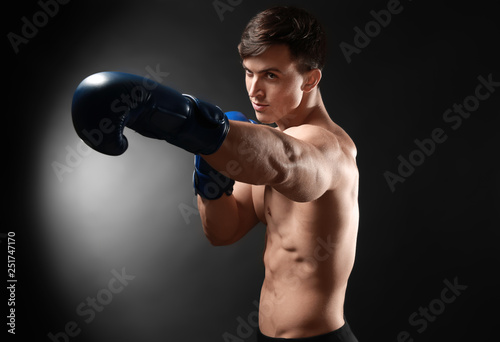 Attractive young boxer on dark background