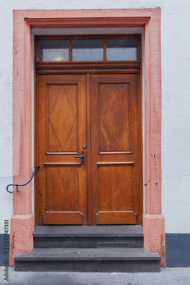 Old wooden door with wooden ornaments in the historic part of the German city of Mainz Old wooden door with wooden ornaments in the historic part of the German city of Mainz
