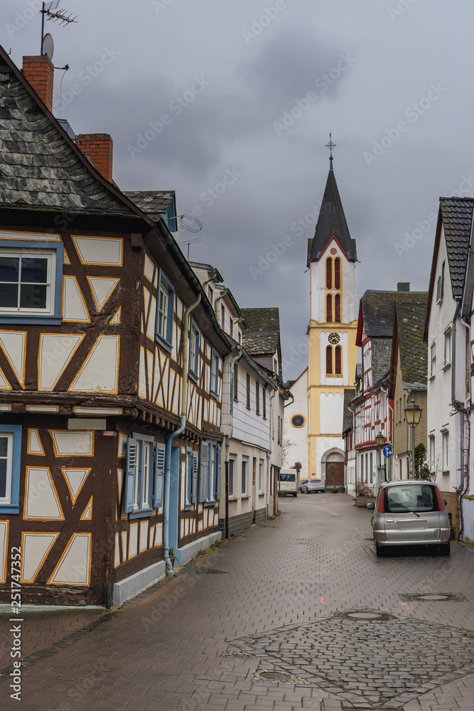 narrow cobbled street with beautiful half-timbered houses and an old cathedral in the town square