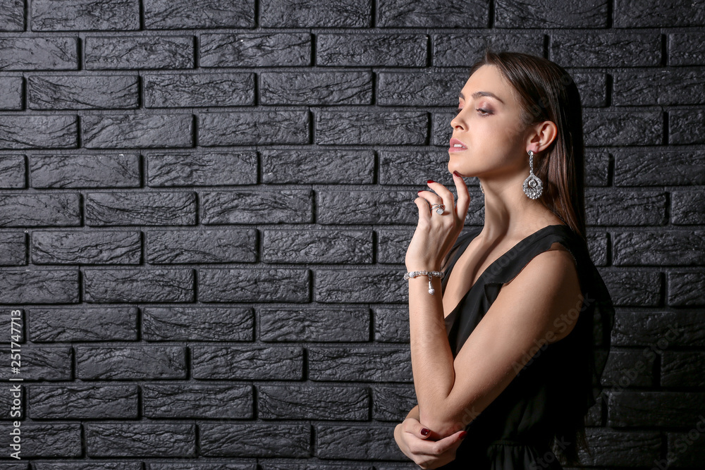 Young woman with beautiful jewelry on dark background Young woman with beautiful jewelry on dark background