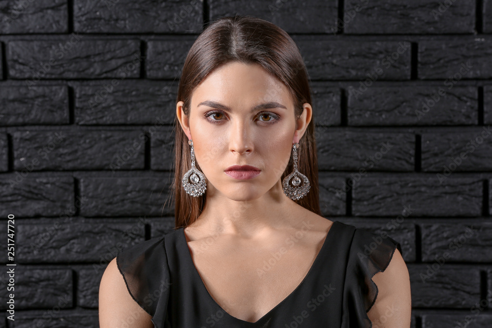 Young woman with beautiful jewelry on dark background