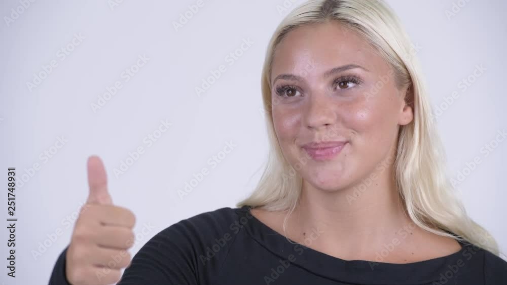 Face of young happy blonde woman giving thumbs up Face of young happy blonde woman giving thumbs up
