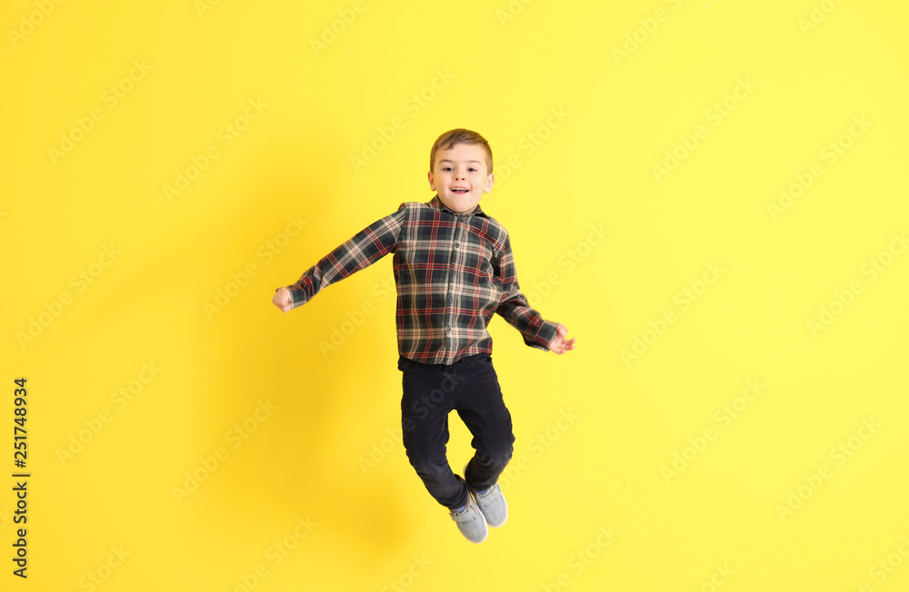 Jumping little boy on color background