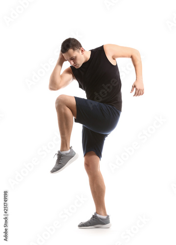 Sporty young man training against white background