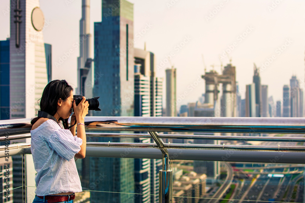 Female tourist taking photo of Dubai cityscape