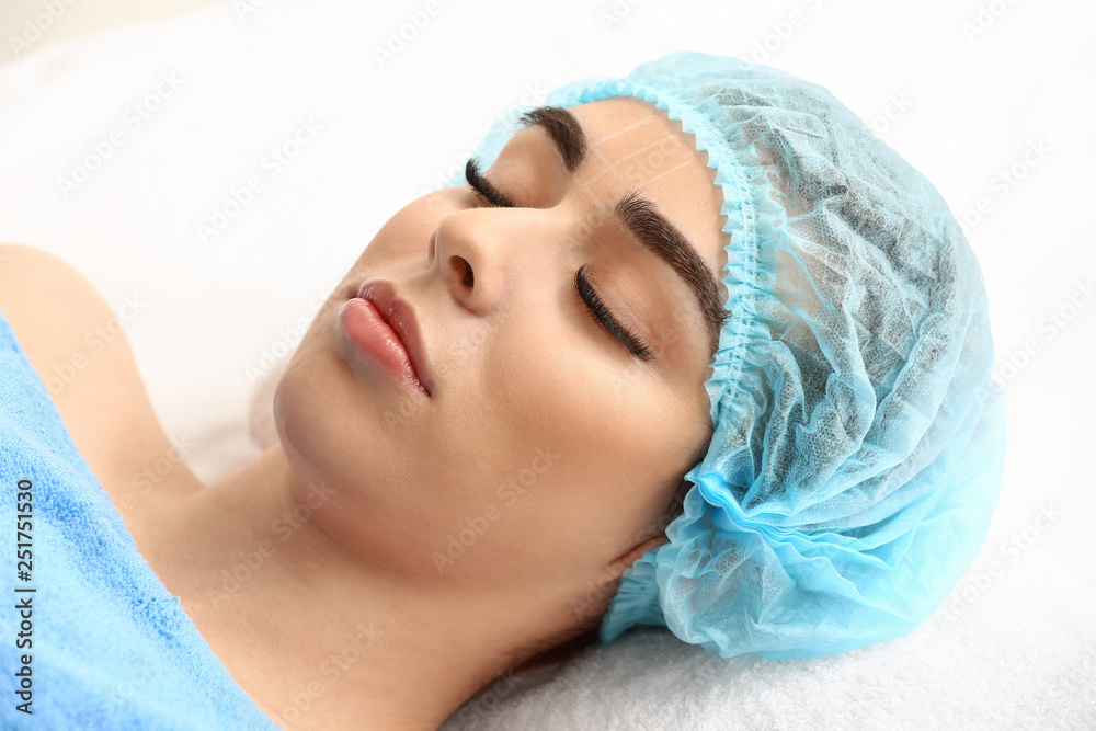 Young woman undergoing eyebrow correction procedure in beauty salon Young woman undergoing eyebrow correction procedure in beauty salon