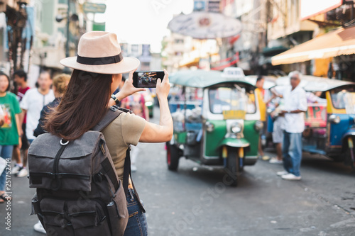 Photography Back view Asian woman tourist backpacker travel in Khao San road, Bangkok, Thail