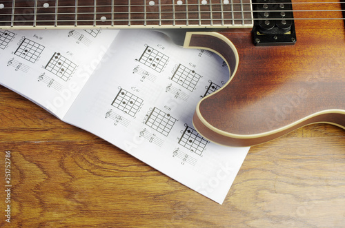 Electric guitar and an open book with guitar chords.