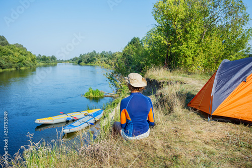 Beautiful girl enjoying a kayak vacation on a beautiful river. Teenager girl kayaking on a hot summer day.