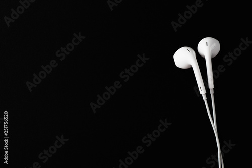 White Earbuds or Earphones on black background. Copy paste space