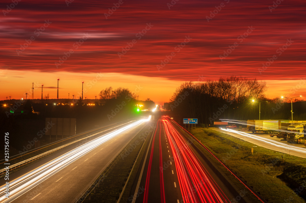  the light trails on motorway highway during a dramatic sunset