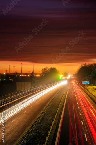  the light trails on motorway highway during a dramatic sunset