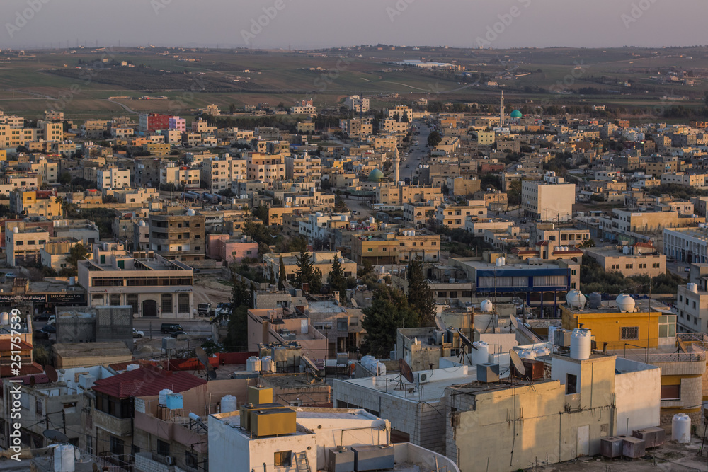 aerial photography of Arabic poor third world city in Middle East part of Earth in evening sunset time with soft colors and small stone buildings   