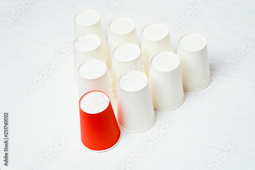 Team leader concept. Red paper glass among white. Top view.