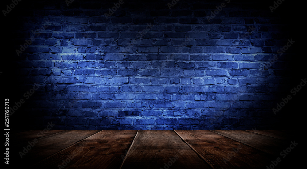 Dark empty room with brick walls and neon lights, smoke, rays. Brick wall, concrete and wooden table.