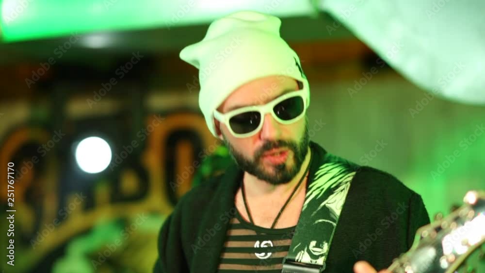 Close up shot of guitarist in sunglasses singing and playing Close up shot of guitarist in sunglasses singing and playing