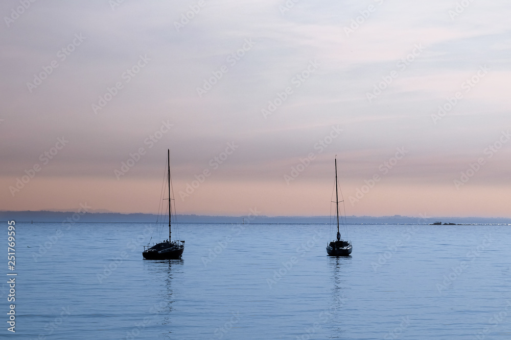 Two sailboat during the sunshine at Garda Lake. Lago di Garda, Italy. October 2018