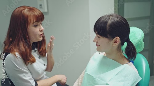 Wallpaper Mural A young woman is sitting on a chair in the dental office on the consultation. Dentist talks about teeth care. Close-up. Torontodigital.ca