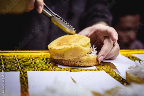 Preparing a banh bo dua, a sweet vietnamese coconut cake, Hoi An night market photo