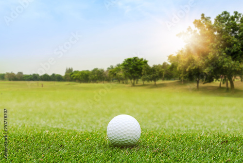 White Golf ball on green course to be shot on blurred beautiful landscape of golf course in bright day time with copy space. Sport, Recreation, Relax in holiday concept	