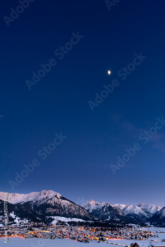 The valley Kleinwalsertal and Oberstdorf, Germany, with Alps in the winter with snow covered landscape at night.