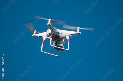 Fototapeta Naklejka Na Ścianę i Meble -  closeup of white quadcopter drone for video appllcation in outdoor on blue sky background