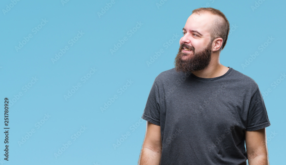 Young caucasian hipster man over isolated background looking away to side with smile on face, natural expression. Laughing confident.