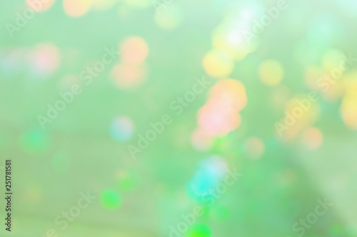 Light green abstract background with multicolored spots.