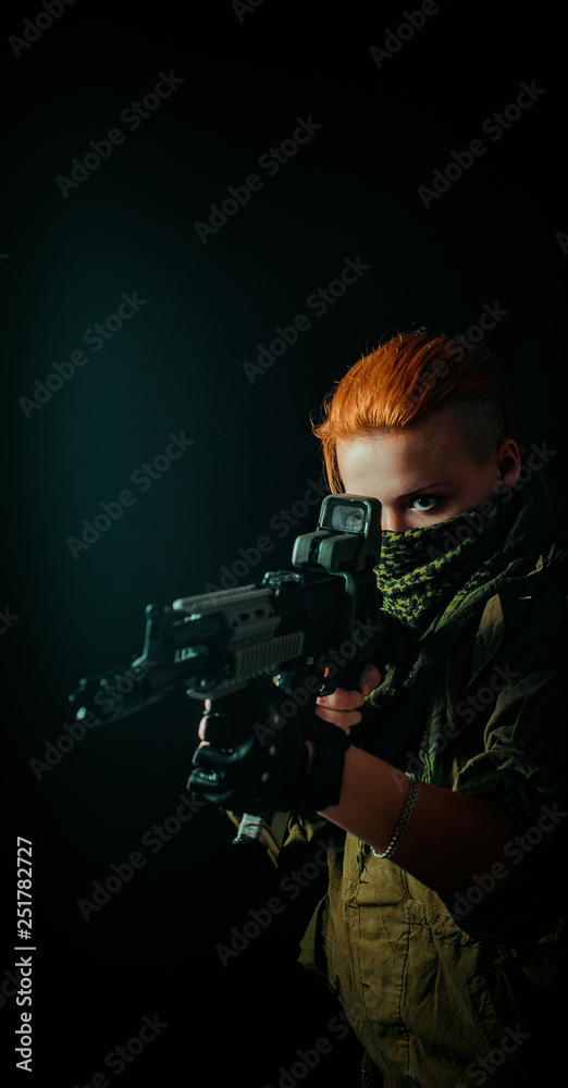 Young woman with red hair and girl with a bandage on his face, hold machinegun in military uniform. Vertical background