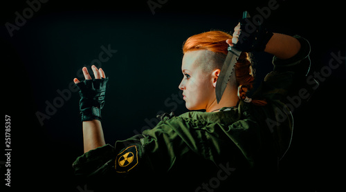 Woman with red hair stand back, keep a knife in hand.