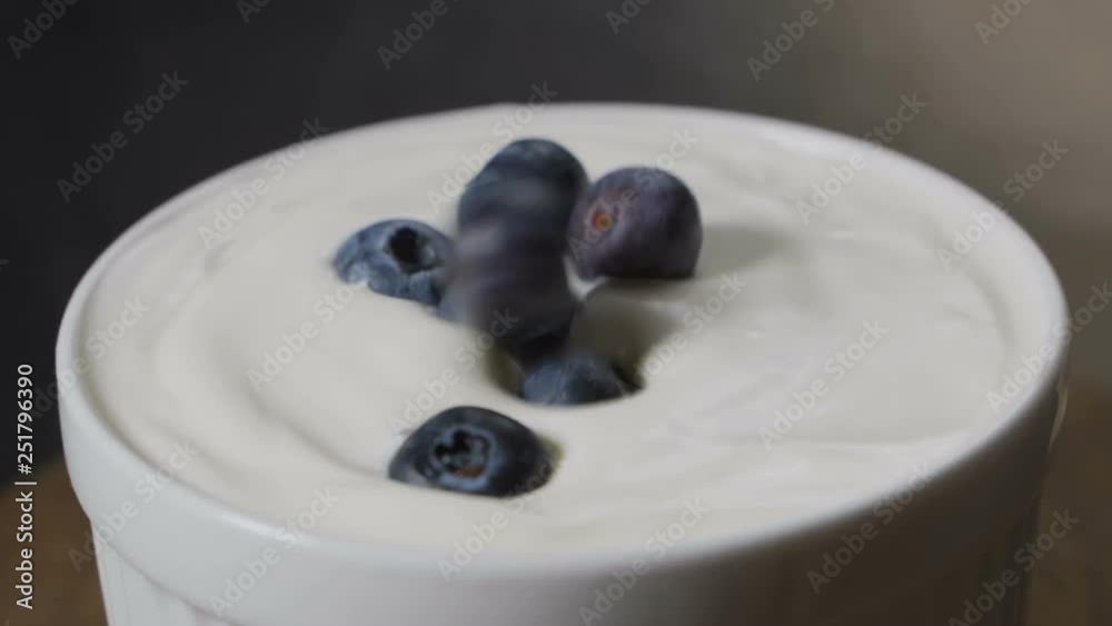 Blueberries falling into milk in slow motion. Blueberries falling into milk in slow motion.