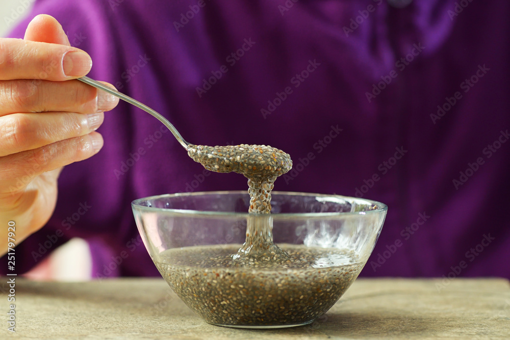 Woman hand with spoon of chia seeds Woman hand with spoon of chia seeds