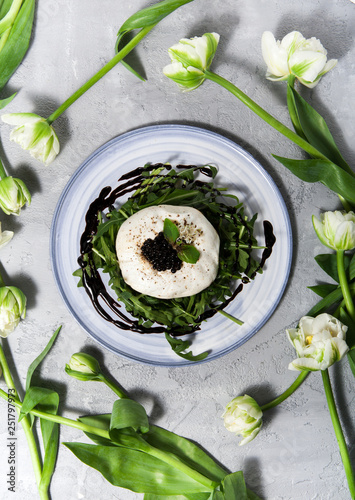 Burratta cheese with arugula and balsamic vinegar pearls on a white background photo