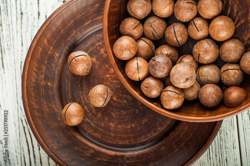 Macedonian nuts on a wooden plate on the background of a textural wooden table. Macedonian nuts close up and copy space