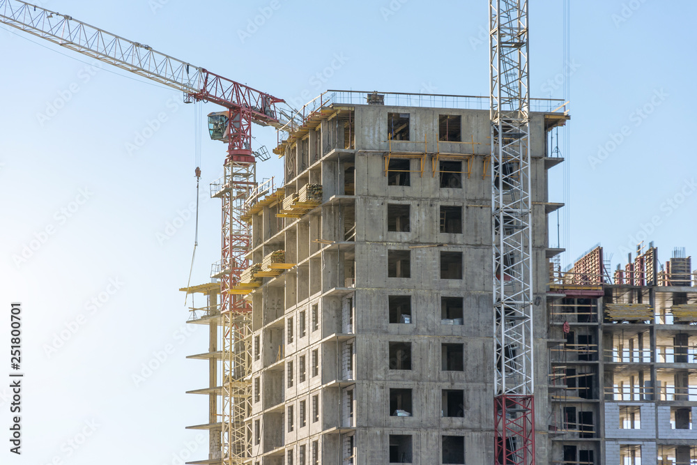 Crane and high-rise residential building. Real Estate Construction
