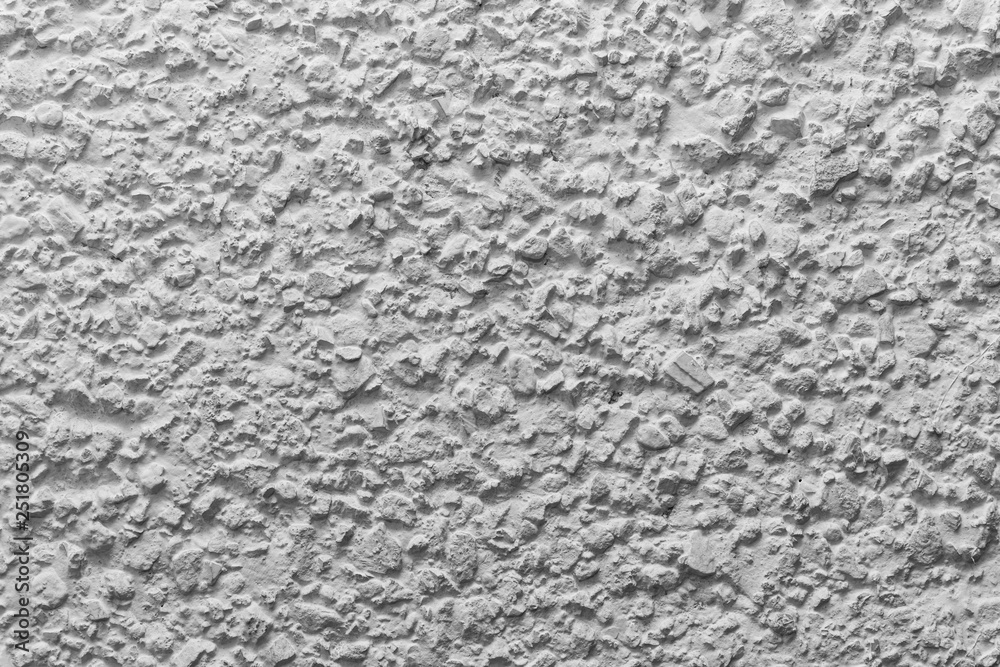 Black and white whitewashed concrete wall interspersed with stones Black and white whitewashed concrete wall interspersed with stones