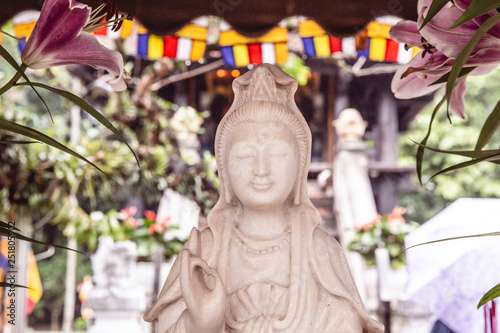 Female Buddha statue with Karana Mudra hand position, in front of the One Pillar Pagoda in Hanoi, Vietnam, Asia photo