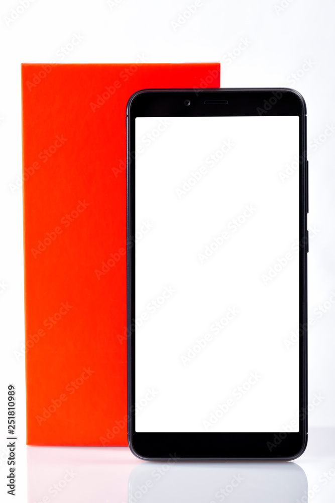 A modern black smartphone with blank screen in front of its box isolated on white A modern black smartphone with blank screen in front of its box isolated on white