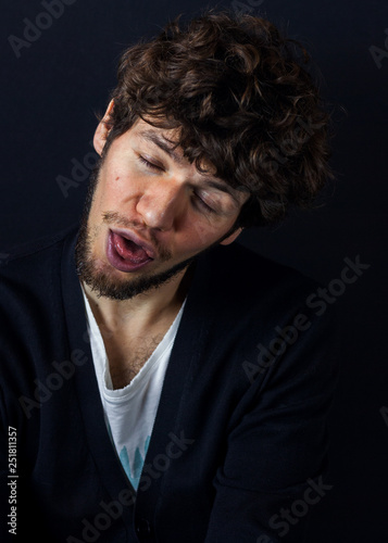 Curly man portrait on dark studio background