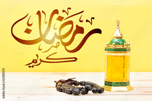 Ornamental Arabic lantern oud perfume with black rosary, Ramadan Kareem Greeting Card. Ramadan Mubarak. Translated: Happy & Holy Ramadan. Month of fasting for Muslims. Arabic Calligraphy photo