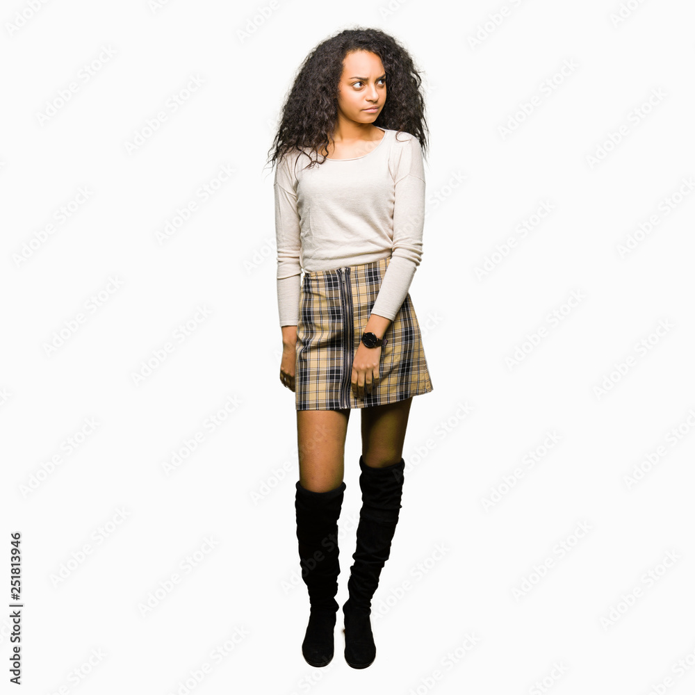 Young beautiful girl with curly hair wearing casual sweater smiling looking side and staring away thinking. Young beautiful girl with curly hair wearing casual sweater smiling looking side and staring away thinking.