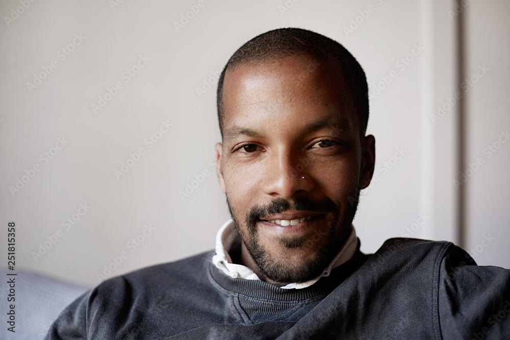 Obraz premium Confident african american man sitting on sofa couch at living room
