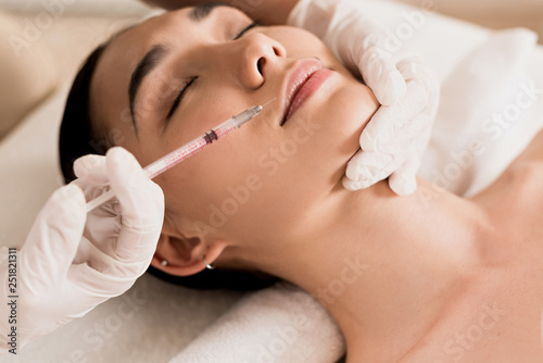 close up of attractive asian woman getting beauty injection at clinic