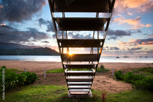 Sun setting through lifeguard stairs, Hanalei Bay, Kauai, Hawaii photo